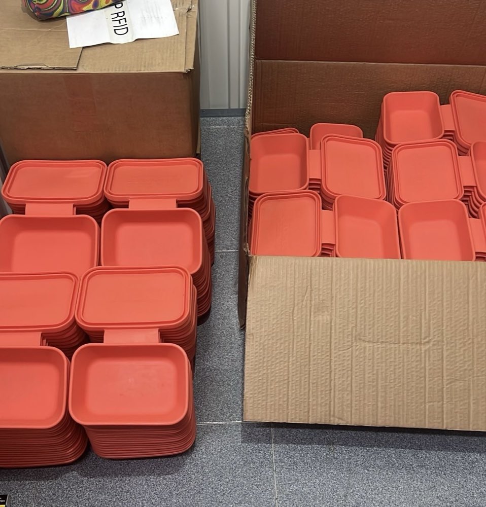 Pilas de cajas reutilizables coral de la primera producción, en cajas de cartón